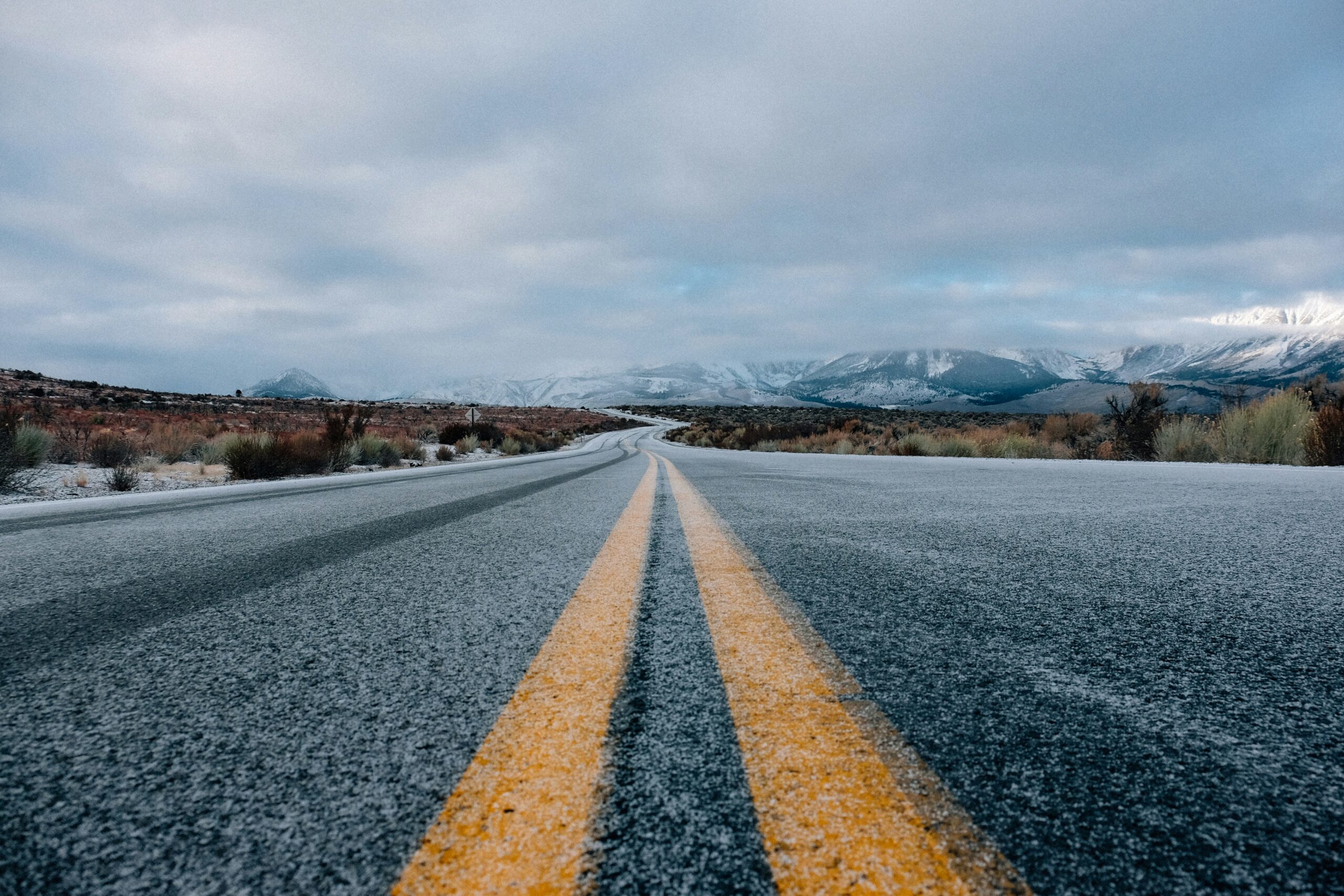 image of the center yellow lines of the road with mountains in the background